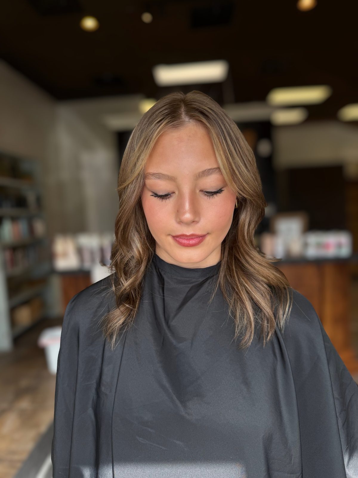 Soft brunette with face-framing blonde highlights and curtain layers