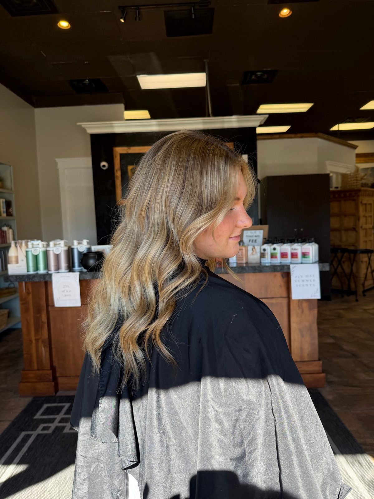 Lived-in golden blonde balayage with loose waves, side view