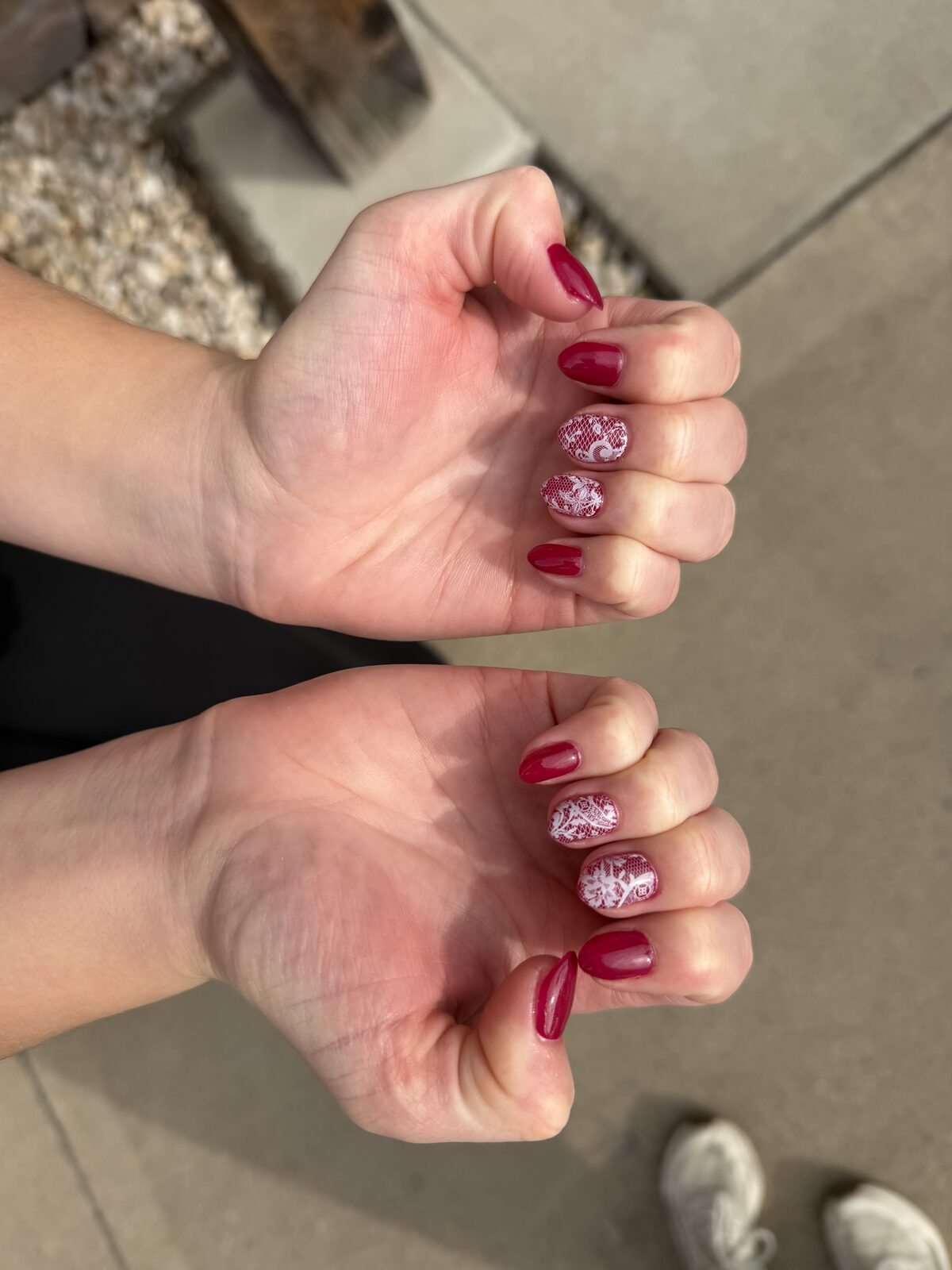 Burgundy gel manicure with white lace accent nails