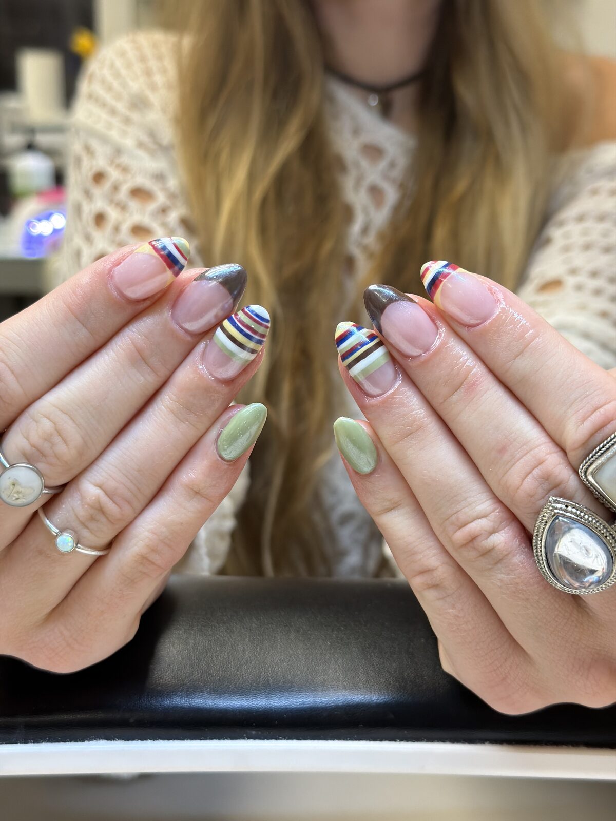 Rainbow striped French tips mixed with sage green and charcoal almond nails