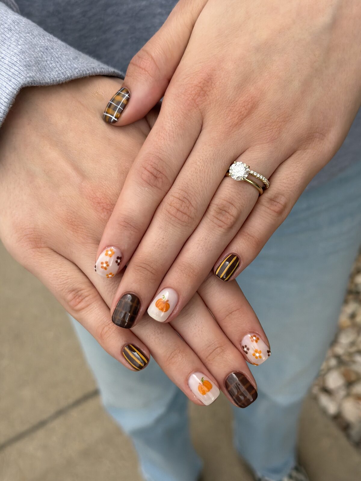 Fall nail art with hand-painted pumpkins, orange florals, and brown plaid — Logan, UT